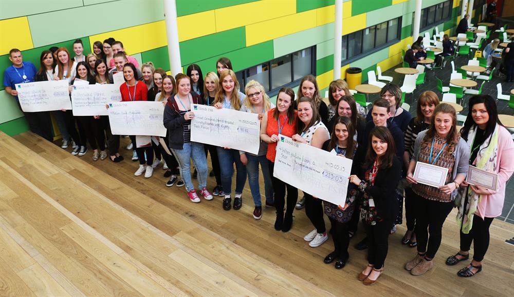 Fundraising students with their bumper cheques, joined by Liz Credgington, of When You Wish Upon a Star (front row, first right) and Simon Cross, of Make a Wish Foundation UK (first left)