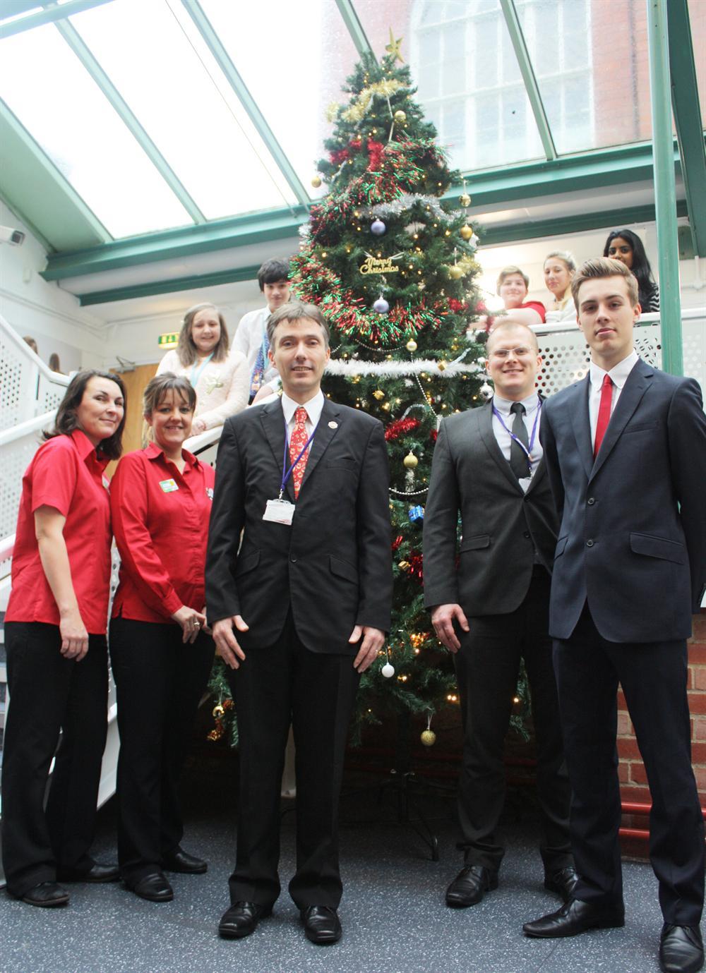 Principal of Vision Studio School Andy Campbell (centre front) with deputy principal Emmet Bunting, Debbie and Hayley from Asda (in red) and students