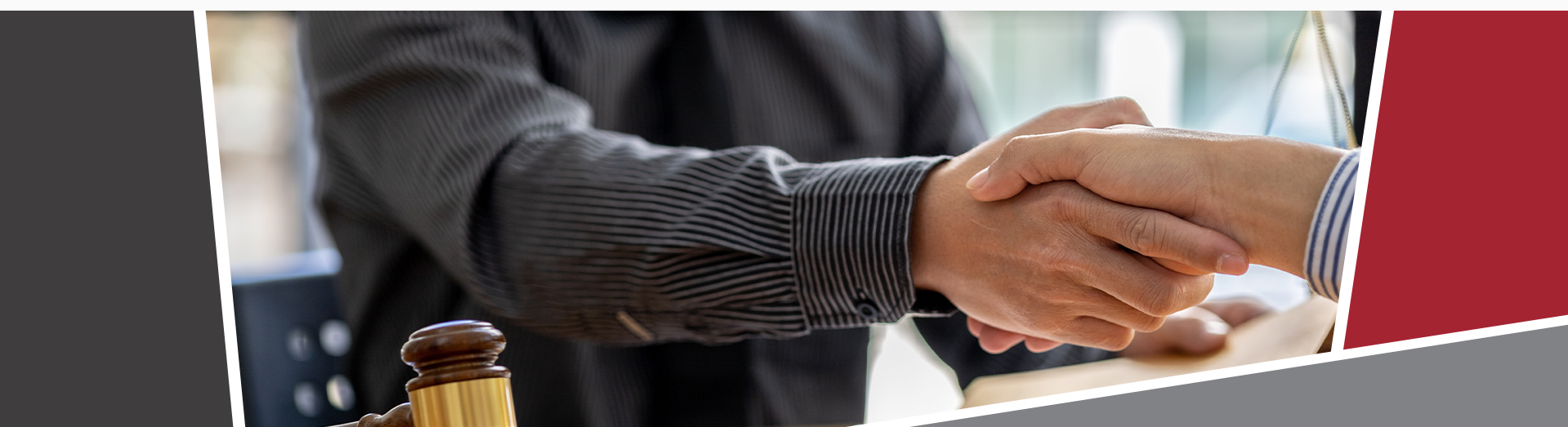 Two people shaking hands with documents and a gavel on the desk