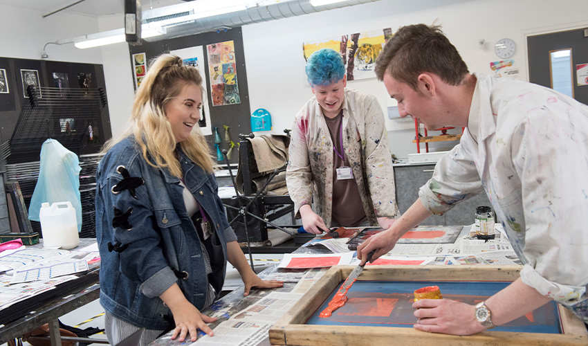 An image of students using paint supplies to make art.