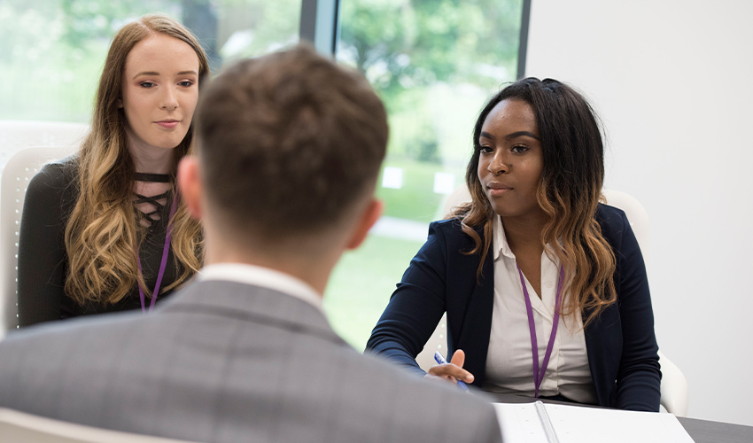 Business tutors having a mock interview with a student.