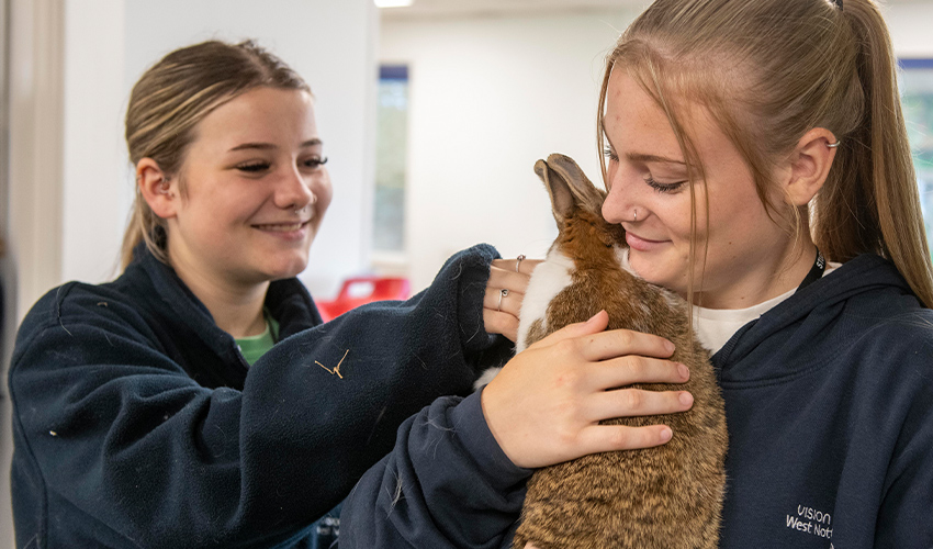 Image of 2 learners holding a bunny