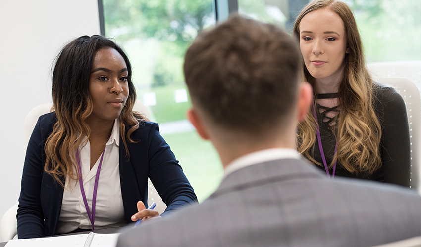An image of students and staff taking part in a mock interview.
