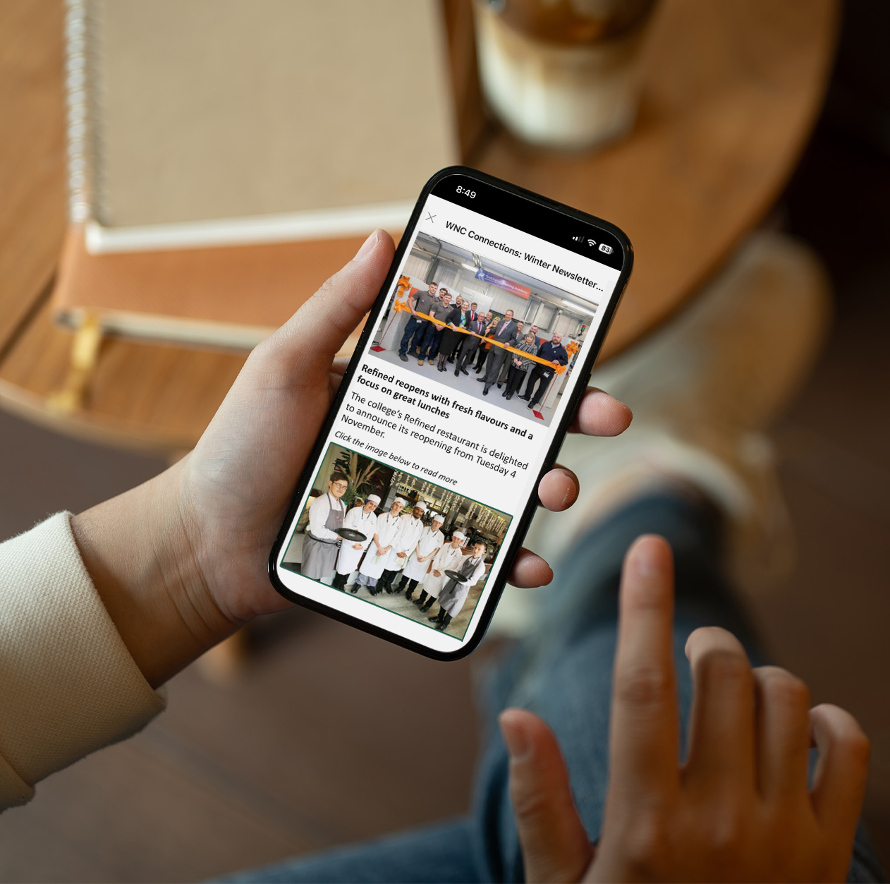 Image of an adult scrolling through a newsletter on their phone