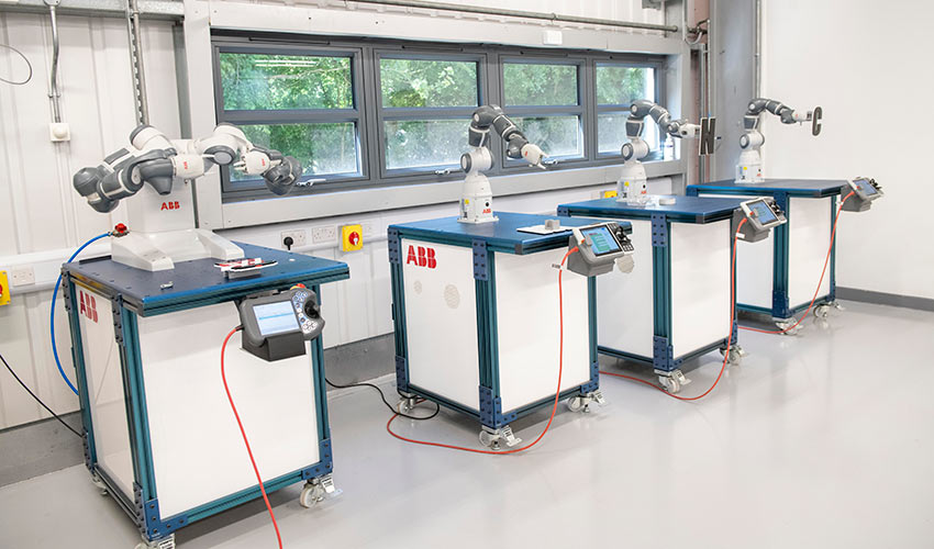 A row of ABB collaborative robots mounted on mobile workstations, demonstrating flexible automation technology for training purposes.