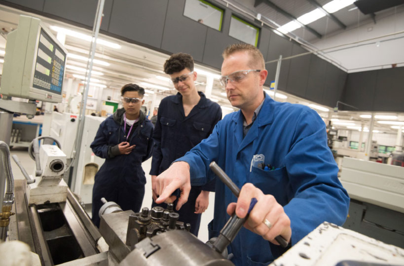 Students are taught to use industrial machinery by teachers with experience.
