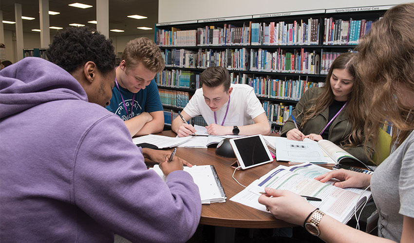 Group of students revising and doing school work in the library