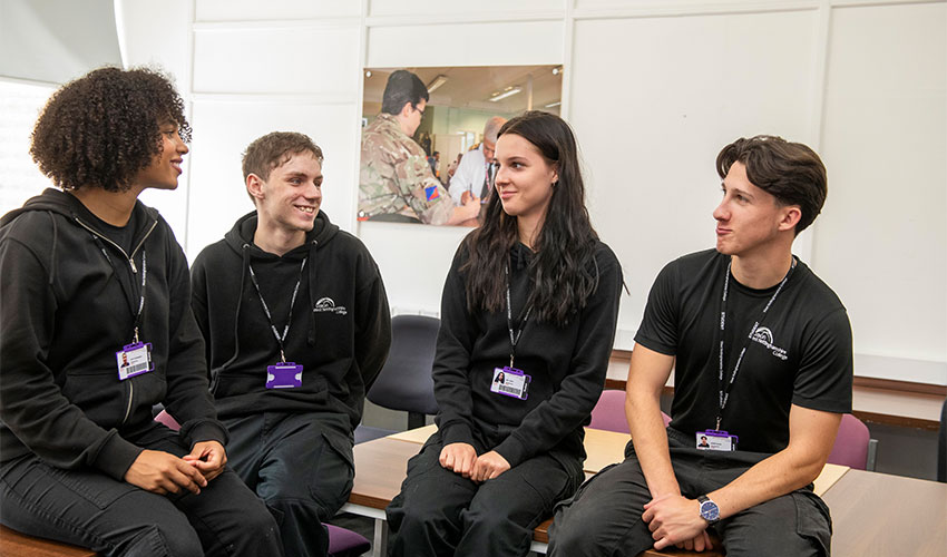 Group of students in their sport uniform sitting on a table