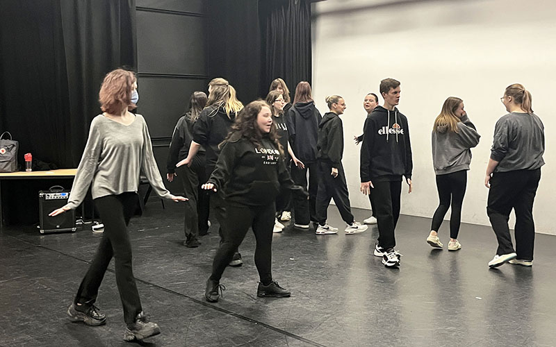 Students getting into character with their body language before the masks were tried