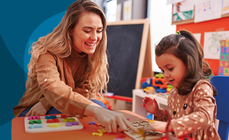 Image of a young women playing with a young child in a nursery.