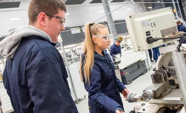 Image of two young engineering students using a CNC machine.