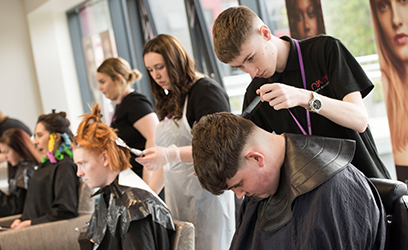 Image of a group of hairdressing students cutting clients hair