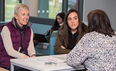 photo of member of staff talking to a parent and student