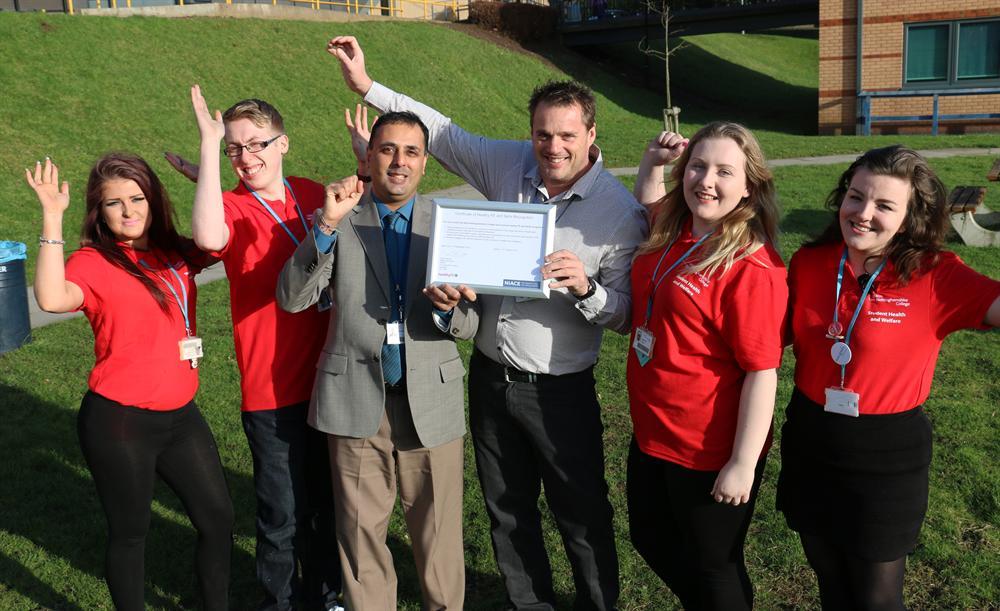 Health champions in red celebrate the accolade with Paul Rana and Mark Cantrill