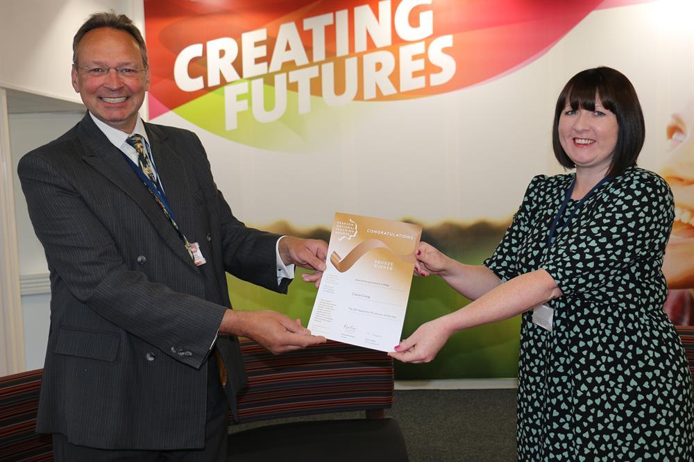 Claire receives her certificate from principal Andrew Cropley after being named as a bronze winner in this year’s Pearson National Teaching Awards.