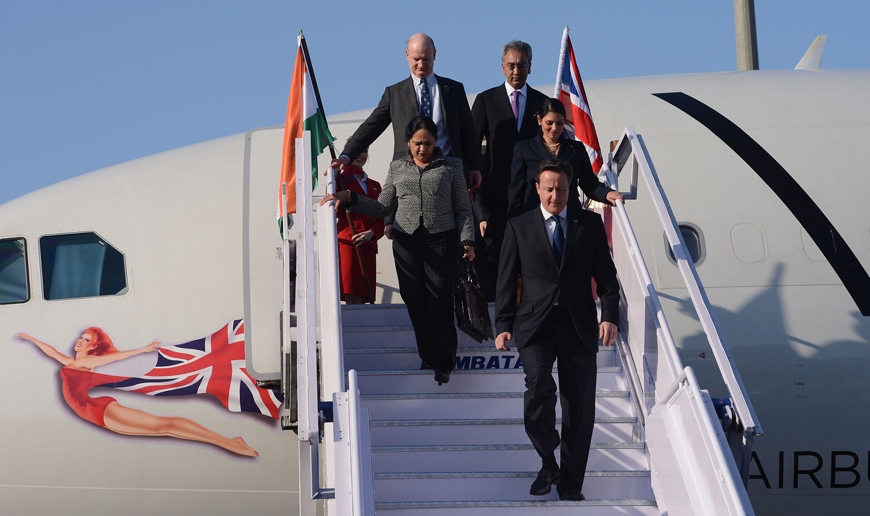 Asha (second row, left) arrives in Mumbai with Prime Minister David Cameron