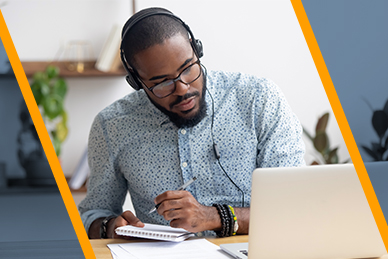 An image of a black male wearing heaphones working on a laptop.