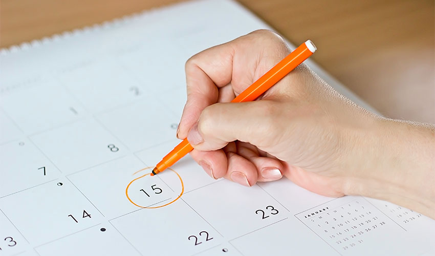 Person circling a date on a calendar.