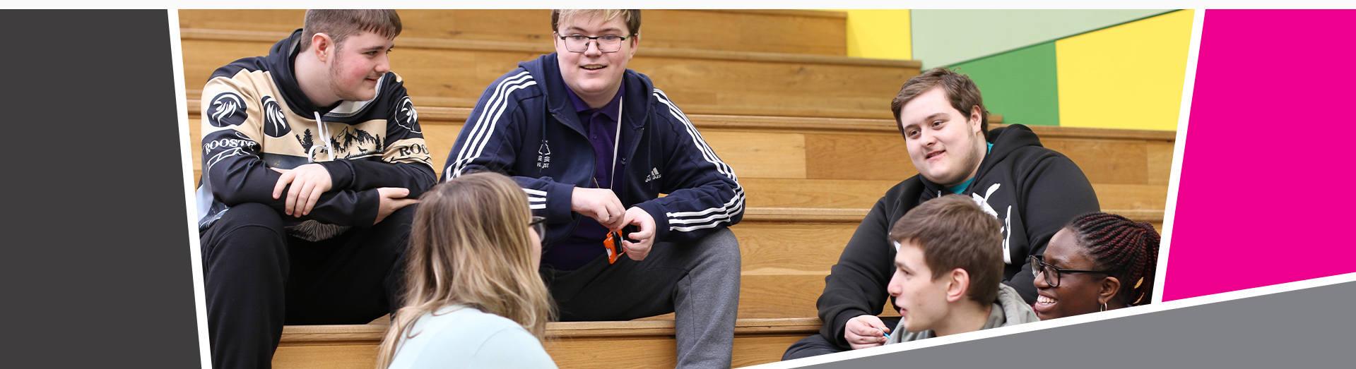 An image of 6 students sat on some stairs talking together.
