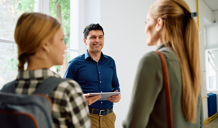 A teacher talking to a student and their parent.